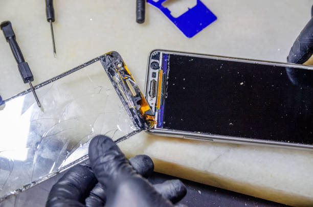 istock Specialist replaces a cracked screen on a white smartphone close-up 1244720856