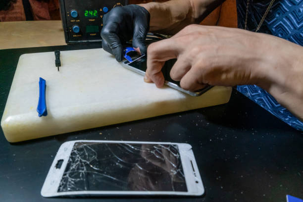 istock Specialist replaces a cracked screen on a white smartphone close-up 1244721969