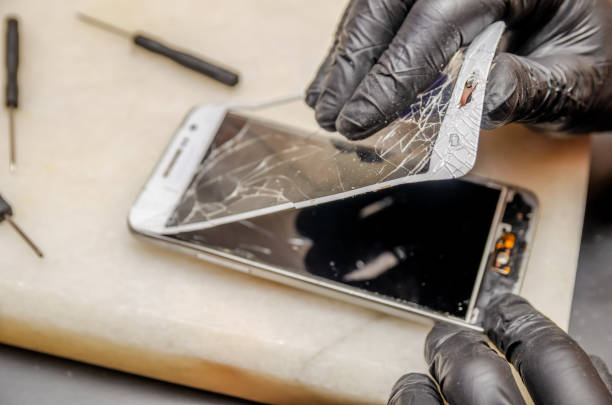 istock Technician or engineer opening broken smartphone for repair or replace new part on desk 1244721987