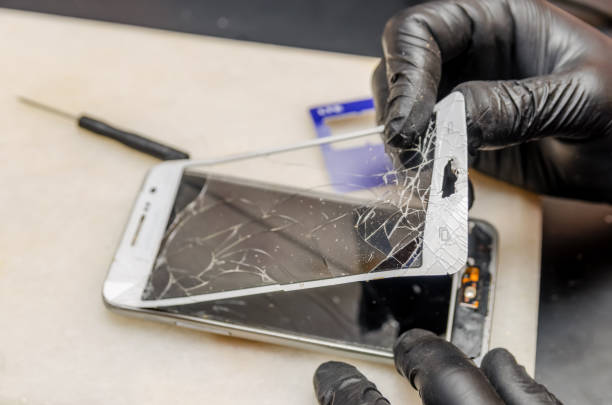 istock Technician or engineer opening broken smartphone for repair or replace new part on desk 1244722313