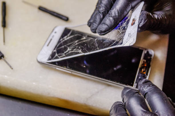 istock Technician or engineer opening broken smartphone for repair or replace new part on desk 1244722537