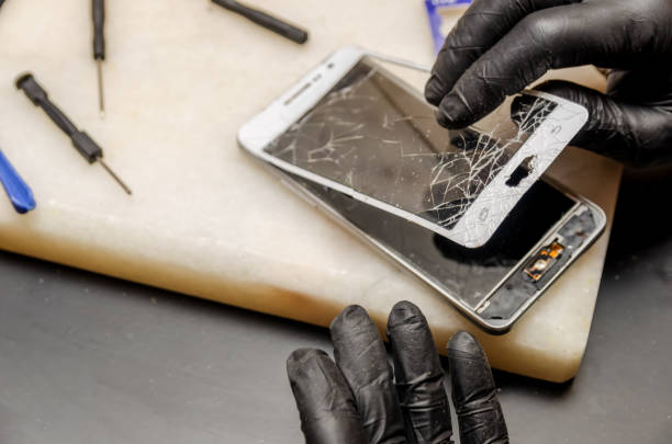 istock Technician or engineer opening broken smartphone for repair or replace new part on desk 1244723638
