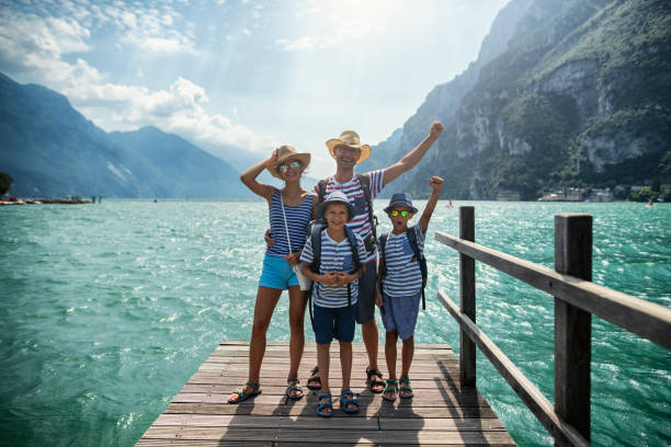 familie steht auf pier und genießt den blick auf den gardasee - family vacation stock-fotos und bilder