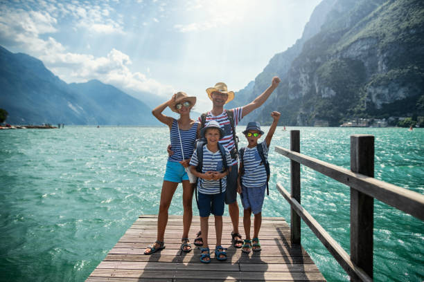 familia de pie en el muelle y disfrutando de la vista del lago de garda - vacaciones viaje fotos fotografías e imágenes de stock