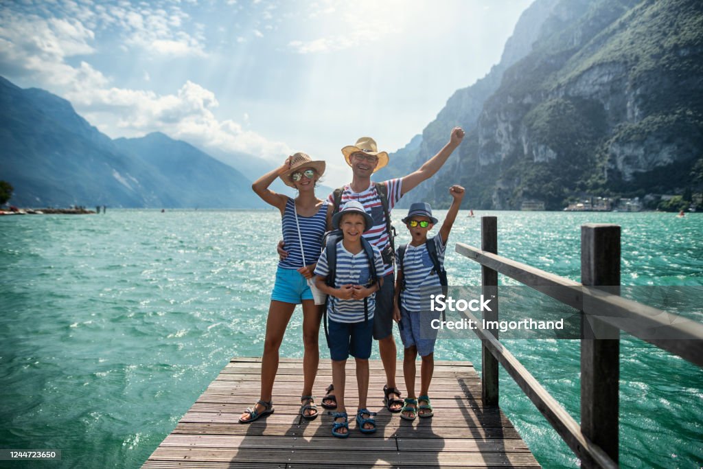 桟橋に立つ家族とガルダ湖の景色を楽しむ - 家族のロイヤリティフリーストックフォト