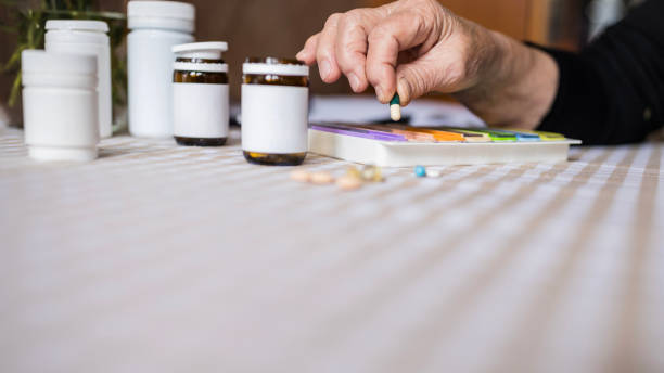 ввод таблетки в еженедельной таблетки организатора - vitamin pill picking up pill capsule стоковые фото и изображения