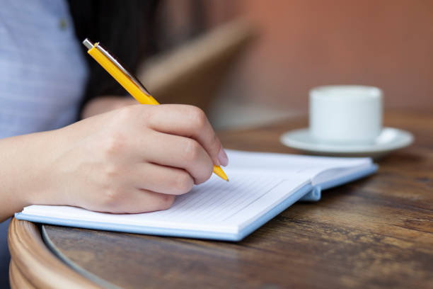 istock woman hand notepad and coffee 1244734831