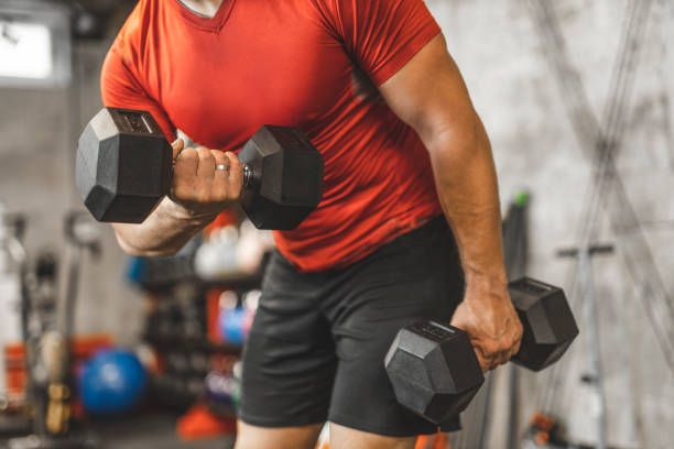 istock Unrecognizable strong man lifting weights and doing exercises for triceps at gym 1244746932