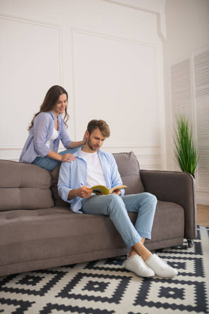 istock Young man studying before exam, his wife touching his shoulder 1244753307