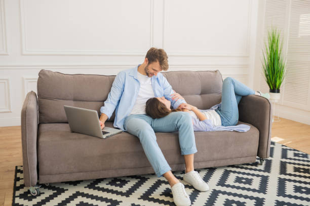 istock Young bearded man working on laptop while his wife resting 1244753941