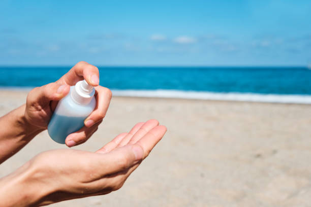 istock man on the beach disinfecting his hands 1244754581