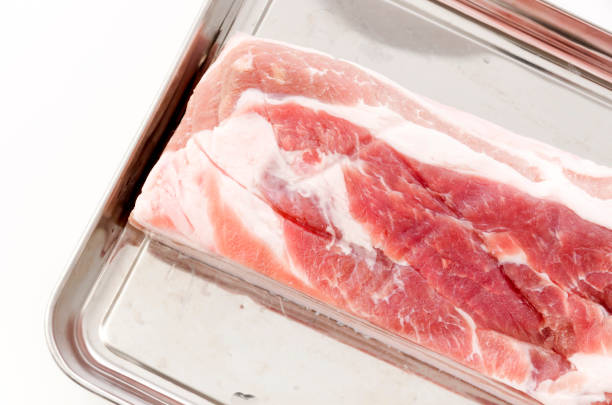 istock Raw Pork belly on a Stainless steel tray on white background 1244759436