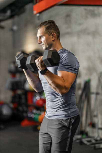 istock Strong man lifting weights and doing exercises for triceps at gym 1244776500