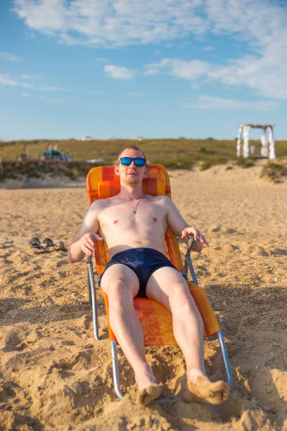 istock young man sits on a deck chair by the sea 1244787745