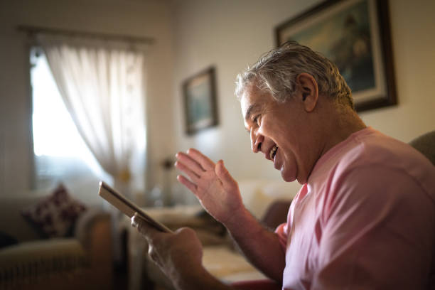istock Senior man doing a video call on digital tablet at home 1244794403