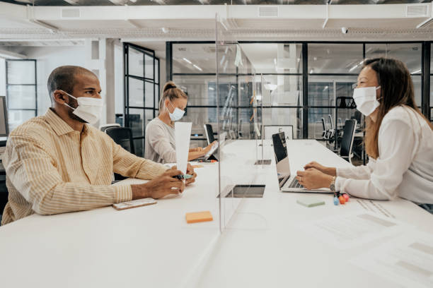 istock Businesspeople working at office with glass partition dividing them 1244797764