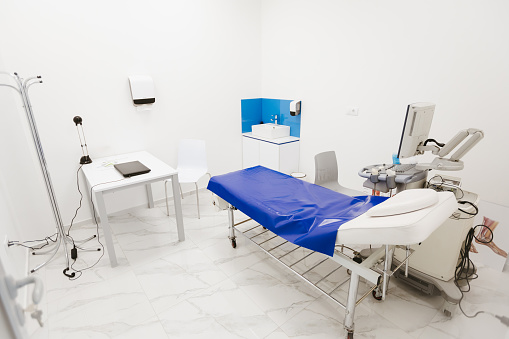 Ultrasound machine, medical trolley and examination table in hospital, above view