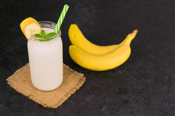 istock Banana and yogurt smoothies on a black background. Copy space. 1244807926