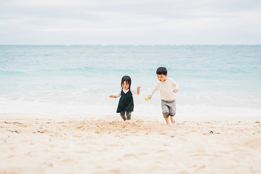 Asian brother and sister playing in the beach.