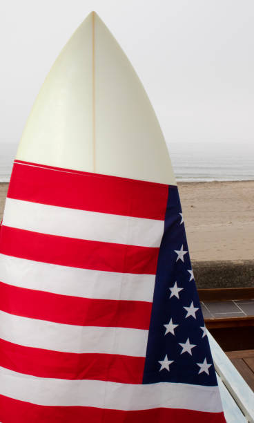 istock USA Flag on a white surfboard with a straw hat, black background, and a guitar. 1244821102
