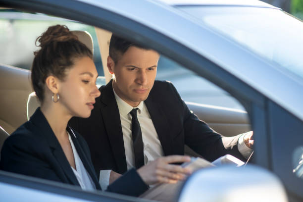 istock Serious man and woman with documents in a car 1244847833