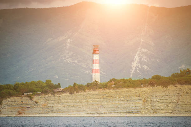 faro costero en el borde de una orilla rocosa en el mar negro, la ciudad de gelendzhik. paisaje. verano. - arrival beacon blue nautical vessel fotografías e imágenes de stock