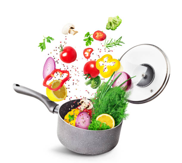 istock Cooking concept. Vegetables and bacon are falling on a pan isolated on white background. Healthy food. 1244863853