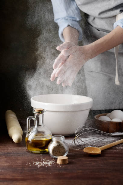 istock Women's hands shake off the flour. Baking ingredients on the table. 1244877945