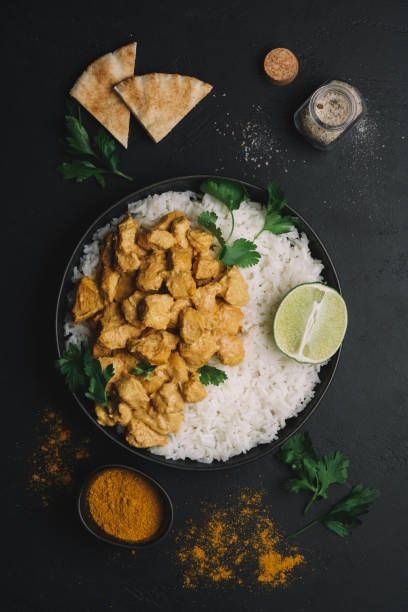 istock Indian Butter chicken curry with basmati rice in bowl on black background. Flat lay, copy space 1244882863