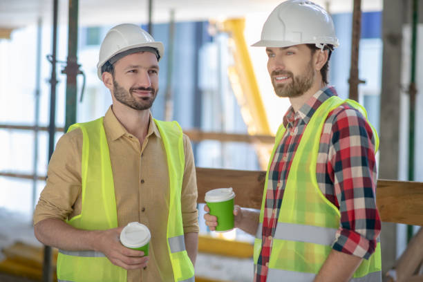 istock Building workers in yellow vests and helmets having coffee break 1244892796