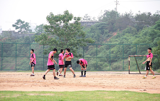 Jiangxi, China - March 11, 2012: Colour photograph of a group of young asian soccer football players, playing on an outdoor court in Ganzhou's Jiangxi province, China