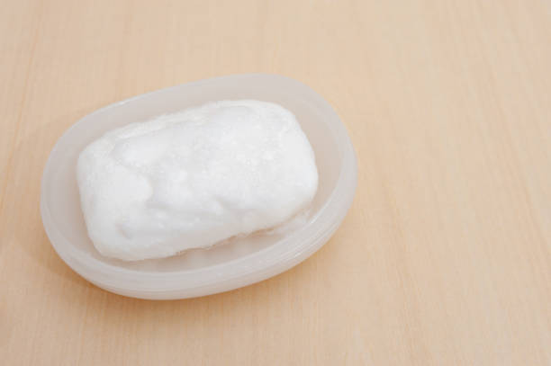 istock White soap with foam in soap dish. Isolated on beige background. 1244928494