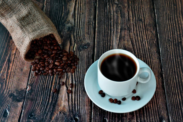istock white cup of coffee on a wooden table with scattered grains 1244934500