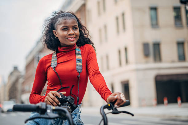 istock Black woman on bicycle with digital camera 1244935153