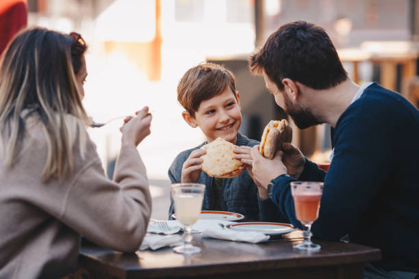 istock Father, son and mother eating food and drinking inside a restaurant 1244936408