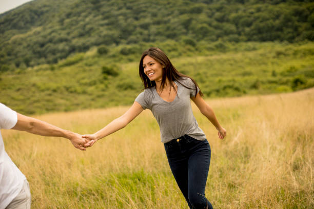 istock Young couple in love walking through grass field 1244941693