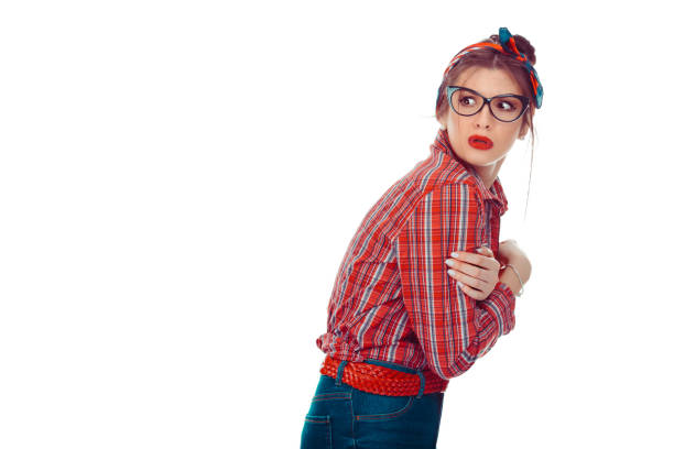 Nervous scared neurotic woman looking back. Closeup portrait of a beautiful girl in red checkered shirt and jeans with retro bow on head isolated on white background. Mixed race, hispanic, caucasian