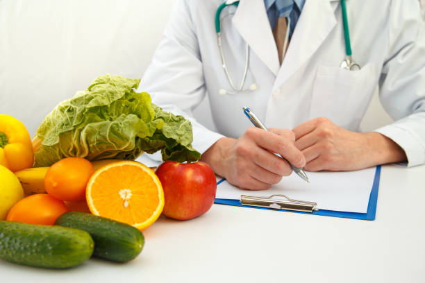 nutricionista médico escrevendo plano de dieta na mesa - dietology - fotografias e filmes do acervo