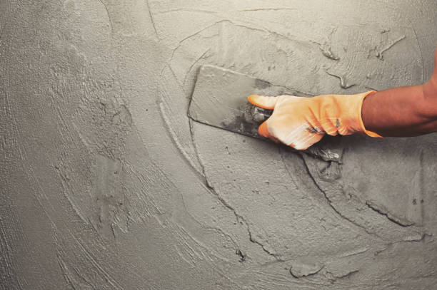 hand of worker plastering cement at wall for building house - plaster imagens e fotografias de stock