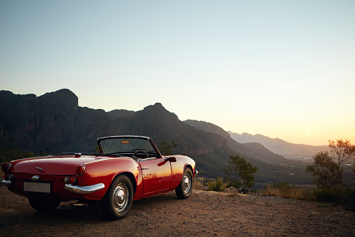 Shot of a vintage car parked on the side of a mountain