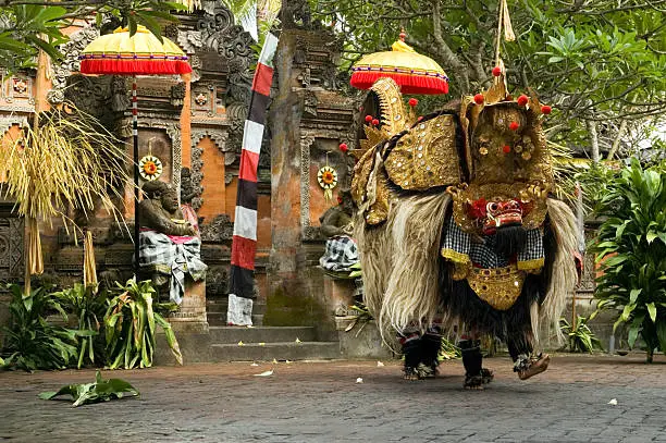 Photo of Barong dance in Bali, Indonesia next to tropical foliage