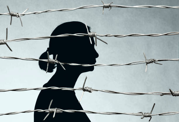 Woman Prisoner Behind Barbed Wire Woman Prisoner Behind Barbed Wire domestic violence stock pictures, royalty-free photos & images