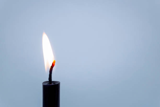 istock Closeup of Candlelight burning stick black on blue background With copy space 1245011423