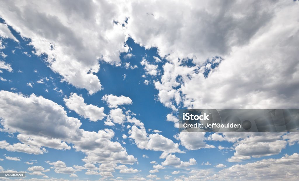 Cumulus Clouds in a Blue Sky Cumulus clouds appear in a blue sky over Rogers Lake near Flagstaff, Arizona, USA. Arizona Stock Photo