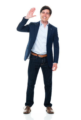 Front view of aged 20-29 years old with short hair caucasian young male business person standing in front of white background wearing jeans who is happy and greeting and showing high-five