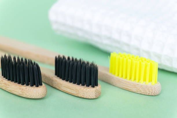 istock Eco natural bamboo toothbrushes on green background with waffle towel. Zero waste concept. Choice plastic free items. Selective focus 1245023961