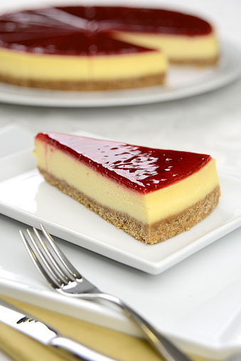 raspberry  cheesecake with yellow cream in the dish on the table