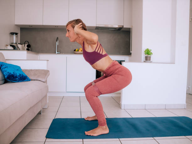 istock Young woman exercising at home doing so indoor workouts using a resistance band 1245033899