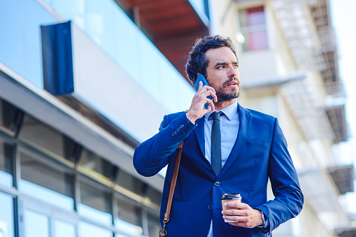 Shot of a young businessman talking on a cellphone while out in the city