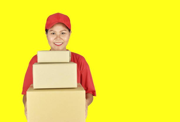 istock Delivery woman holding parcel box for customer services on yellow background. 1245041174